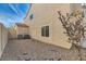 Gravel backyard featuring a neutral-colored two-story house with AC units and small sparse landscaping at 23 Antero Dr, Henderson, NV 89074