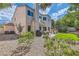 Back exterior of the home highlighting a patio, seating, manicured lawn, and lush greenery at 23 Antero Dr, Henderson, NV 89074