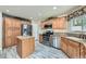 Bright kitchen featuring wood-look tile flooring, wood cabinets, island, and stainless appliances at 23 Antero Dr, Henderson, NV 89074