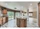 Open kitchen featuring wood-look tile flooring, wood cabinets, island, natural light, and open layout at 23 Antero Dr, Henderson, NV 89074