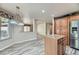 Bright kitchen featuring wood-look tile flooring, wood cabinets, island, stainless fridge and open to living spaces at 23 Antero Dr, Henderson, NV 89074