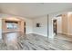 Spacious room featuring wood-look tile flooring, neutral paint, archways to the kitchen and stairway, and TV mount at 23 Antero Dr, Henderson, NV 89074