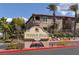 Exterior view of Mission Hills Condominiums featuring lush landscaping, a palm tree, and sign at 2305 W Horizon Ridge Pkwy # 3324, Henderson, NV 89052