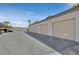 Row of detached garages with beige doors and black asphalt driveway at 2305 W Horizon Ridge Pkwy # 3324, Henderson, NV 89052