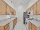 Galley kitchen features ample cabinet space, light countertops, white appliances, and tile flooring at 2305 W Horizon Ridge Pkwy # 3324, Henderson, NV 89052