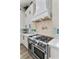 Close up of a modern kitchen featuring stainless steel appliances, white cabinets, and tile backsplash at 2309 Prometheus Ct, Henderson, NV 89074