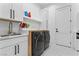 Bright laundry room with marble countertops, modern appliances, and white cabinets at 2309 Prometheus Ct, Henderson, NV 89074