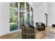 Sunlit living room featuring floor-to-ceiling windows with a view of the lush backyard, and hardwood floors at 2309 Prometheus Ct, Henderson, NV 89074