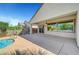 Backyard featuring a sparkling pool, covered patio and mature trees at 2520 Eclipsing Stars Dr, Henderson, NV 89044