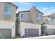 Modern townhome featuring neutral colors, a two-car garage and manicured landscaping at 2536 Catallo St, Henderson, NV 89044