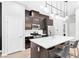 Modern kitchen with stainless steel appliances, dark wood cabinets, and a white quartz countertop island at 2536 Catallo St, Henderson, NV 89044