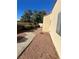 Backyard features gravel landscaping, lush greenery, and concrete walkway along home at 2711 Seabridge Dr, Las Vegas, NV 89121