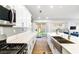 Bright kitchen featuring stainless appliances, modern white cabinets, an island, and sliding doors leading to the backyard at 2913 Bradford Hill Ave, North Las Vegas, NV 89031