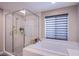 Gorgeous bathroom featuring a glass shower, soaking tub, and a window for natural light at 3066 Casarano Ct, Henderson, NV 89044