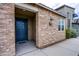 Home's exterior featuring a stone facade, a blue door with inset windows, and desert landscaping at 3066 Casarano Ct, Henderson, NV 89044