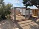 Backyard chicken coop with a brick trim and wire mesh, enclosed by a wooden fence at 325 Ron Ave, Logandale, NV 89021