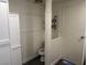 Neutral-toned bathroom stall with mounted shelving and a single-unit toilet at 325 Ron Ave, Logandale, NV 89021