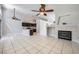 Open living space showcasing a fireplace, tile flooring, and a ceiling fan at 3531 Barrel Bronco Ct, North Las Vegas, NV 89032