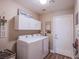 Bright laundry room with a white washer and dryer set and overhead cabinets at 3882 Genoa Dr, Las Vegas, NV 89141