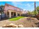 Well-maintained backyard with artificial turf, landscaping, and a covered patio at 4451 Tomer Ln, Las Vegas, NV 89121