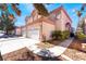 Two-story home boasting a three-car garage, complemented by desert landscaping and a meticulously maintained driveway at 4451 Tomer Ln, Las Vegas, NV 89121