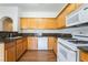 Kitchen with stainless steel sink, granite countertops, wooden cabinets, and white appliances at 4451 Tomer Ln, Las Vegas, NV 89121