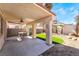 Covered patio featuring a ceiling fan, dining set, and artificial turf at 4451 Tomer Ln, Las Vegas, NV 89121