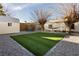 Landscaped backyard with artificial turf, gravel, dining area, and a storage shed at 478 S Water St, Henderson, NV 89015