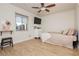 Cozy bedroom with laminate floors, a ceiling fan, a mounted TV, and a large window at 478 S Water St, Henderson, NV 89015