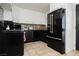 Modern kitchen with stainless steel appliances, contrasting black and white cabinets, and tile flooring at 478 S Water St, Henderson, NV 89015