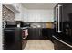 Well-lit kitchen with a mosaic backsplash, black appliances, and white upper cabinets at 478 S Water St, Henderson, NV 89015