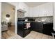 Updated kitchen adjacent to living area with black appliances and white cabinets at 478 S Water St, Henderson, NV 89015