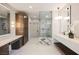 Elegant bathroom boasts dual vanities, a glass-enclosed shower with marble accents, and modern lighting fixtures at 501 Proud Eagle Ln, Las Vegas, NV 89144