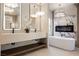 Bright bathroom featuring a marble accent wall, modern vanity, and a freestanding bathtub with fireplace at 501 Proud Eagle Ln, Las Vegas, NV 89144