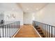 Bright hallway with hardwood floors, black metal railings, and modern artwork at 501 Proud Eagle Ln, Las Vegas, NV 89144