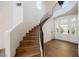 Elegant curved staircase with wood treads and iron railings, leading to a bright foyer with double doors at 501 Proud Eagle Ln, Las Vegas, NV 89144