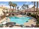 Community pool featuring lounge chairs, tables, palm trees, and a hot tub at 5855 Valley Dr # 2170, North Las Vegas, NV 89031