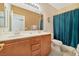 Bathroom featuring double sinks, tile flooring, and blue shower curtain at 5873 Wildhorse Ledge Ave, Las Vegas, NV 89131