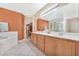 Bathroom featuring a double vanity, soaking tub, and neutral-colored tile flooring at 5873 Wildhorse Ledge Ave, Las Vegas, NV 89131