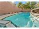 Swimming pool with bright blue water, green tile, and privacy wall at 5873 Wildhorse Ledge Ave, Las Vegas, NV 89131