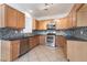 Modern kitchen featuring stainless steel appliances, granite countertops, and tile flooring at 6430 Jackrabbit Run Ave, Las Vegas, NV 89122