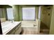 Bathroom with a soaking tub, shower, double sink vanity, and natural light at 6545 Bradford Ln, Las Vegas, NV 89108