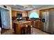 Bright kitchen with stainless steel appliances, granite countertops, tile backsplash, central island, and wooden cabinets at 6545 Bradford Ln, Las Vegas, NV 89108