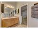 Bathroom with dual sinks, a large mirror, and doorway leading to bedroom at 6917 Leon Ave, Las Vegas, NV 89131