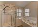 Bright bathroom featuring a glass shower, soaking tub, and tiled walls at 6917 Leon Ave, Las Vegas, NV 89131