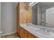 Bathroom with double sinks, wooden cabinets, and a large mirror at 6917 Leon Ave, Las Vegas, NV 89131