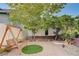 Backyard featuring a wooden swing, mature shade trees, and a brick-paved patio at 7220 Shenandoah Springs Ave, Las Vegas, NV 89131