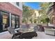 An inviting brick patio with a round table and chairs, nestled between lush greenery and the home's exterior at 7220 Shenandoah Springs Ave, Las Vegas, NV 89131