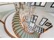 Dramatic view of the curved staircase with chandelier and checkered floor at 7220 Shenandoah Springs Ave, Las Vegas, NV 89131