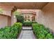 Landscaped courtyard entrance featuring lush greenery, a tiled walkway, and a glimpse of the home's interior at 7607 Boca Raton Dr, Las Vegas, NV 89113